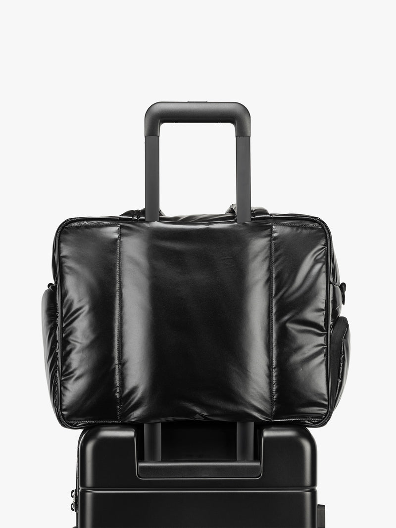 CALPAK Luka Duffel in shiny black on a white background with luggage sleeve
