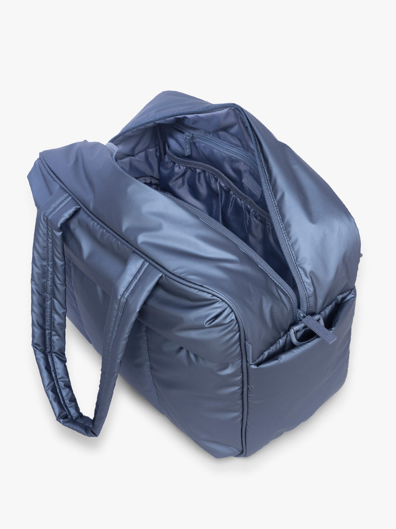 Opened view of CALPAK Luka Duffel in metallic dark blue material Metallic Indigo