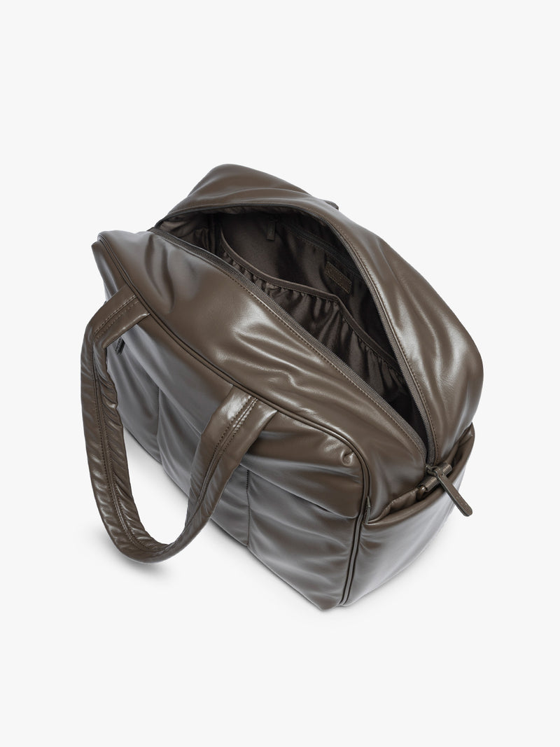 Top view with zipper open of the A dark brown Mushroom CALPAK Luka Duffel in vegan leather with dual top handles and a front zippered pocket, photographed against a clean white background