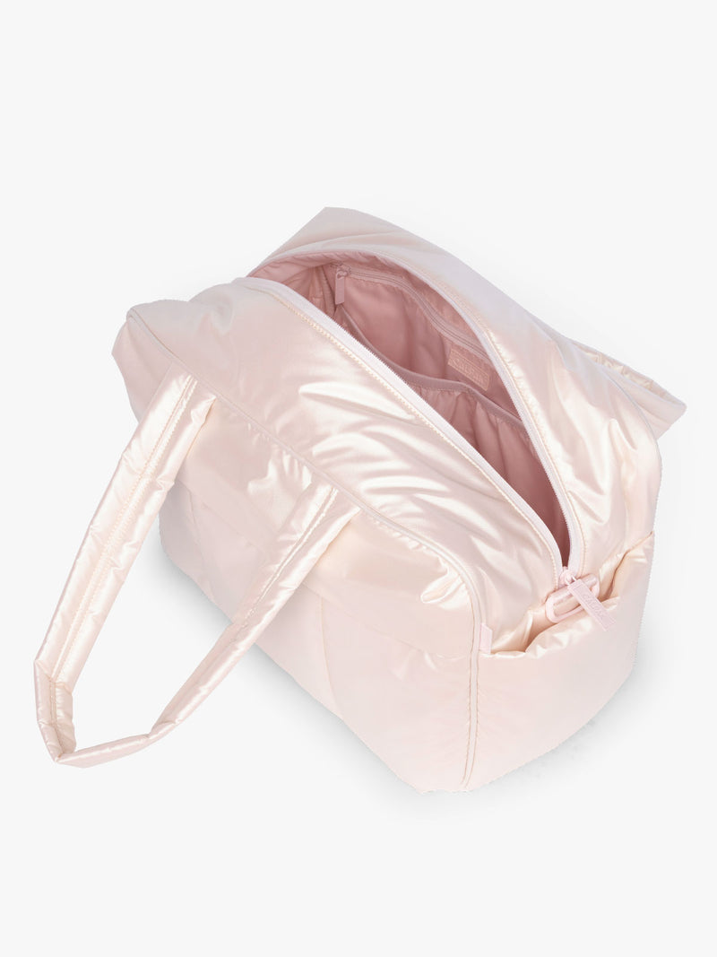 Opened CALPAK Luka Duffel in light pink shiny Pearlescent