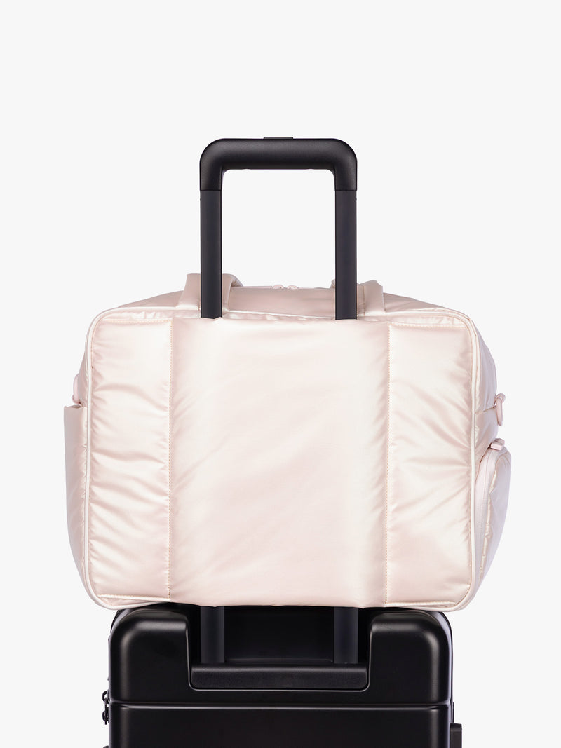 Luggage trolley sleeve of CALPAK Luka Duffel in light pink shiny Pearlescent