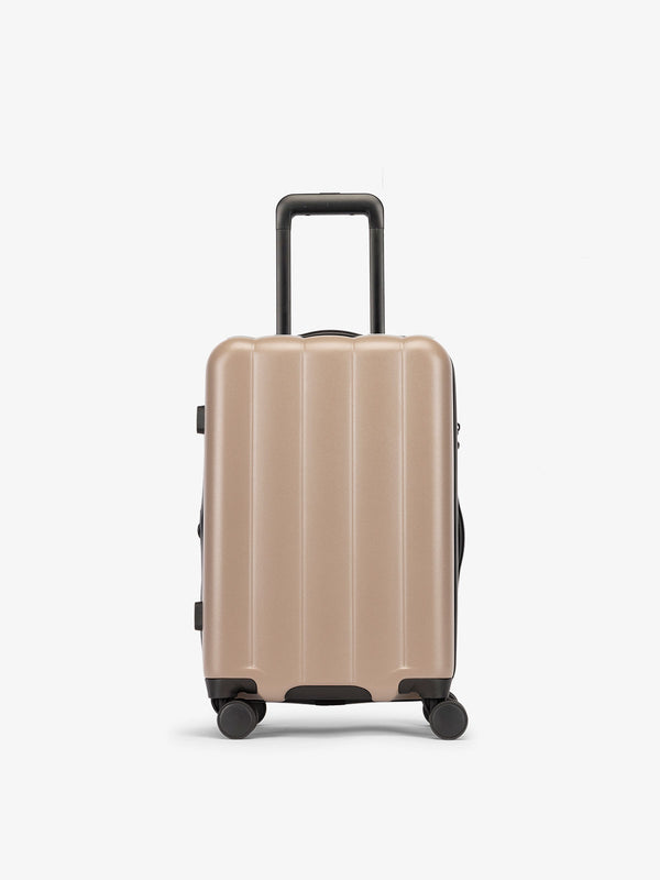 Brown chocolate CALPAK carry-on luggage made from an ultra-durable polycarbonate shell and expandable by up to 2"