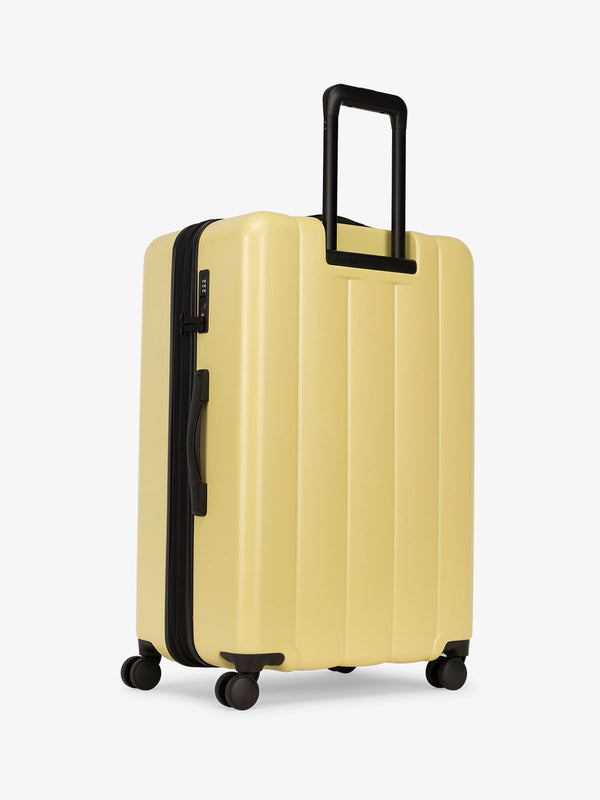 CALPAK large luggage featuring dual spinner wheels and bottom grab handle in butter yellow