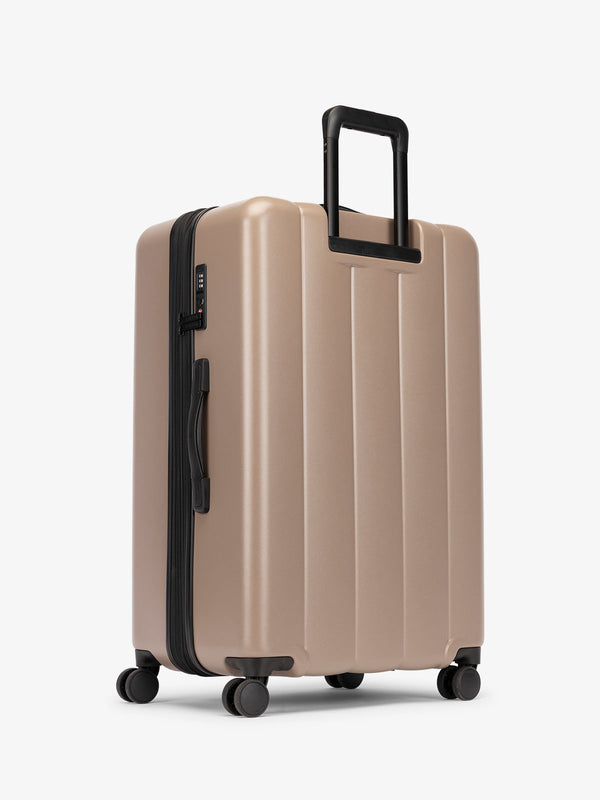 CALPAK large luggage featuring dual spinner wheels and bottom grab handle in chocolate