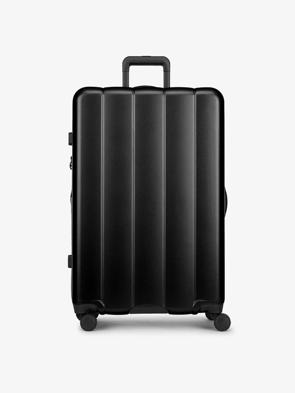 Black large luggage made from an ultra-durable polycarbonate shell and expandable by up to 2"