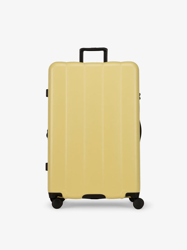 CALPAK yellow butter large luggage made from an ultra-durable polycarbonate shell and expandable by up to 2"