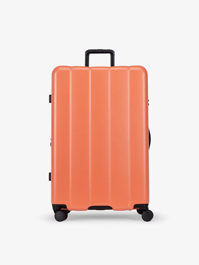 CALPAK persimmon orange large luggage made from an ultra-durable polycarbonate shell and expandable by up to 2