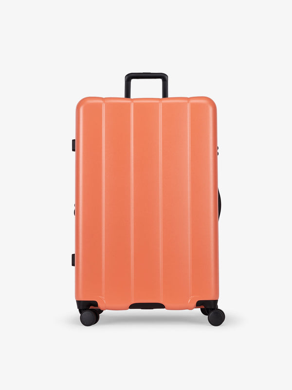 CALPAK persimmon orange large luggage made from an ultra-durable polycarbonate shell and expandable by up to 2"