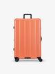 CALPAK persimmon orange large luggage made from an ultra-durable polycarbonate shell and expandable by up to 2"; LCO1028-PERSIMMON