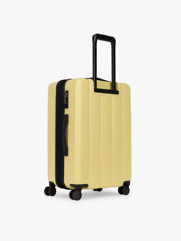 CALPAK medium luggage featuring dual spinner wheels and bottom grab handle in yellow