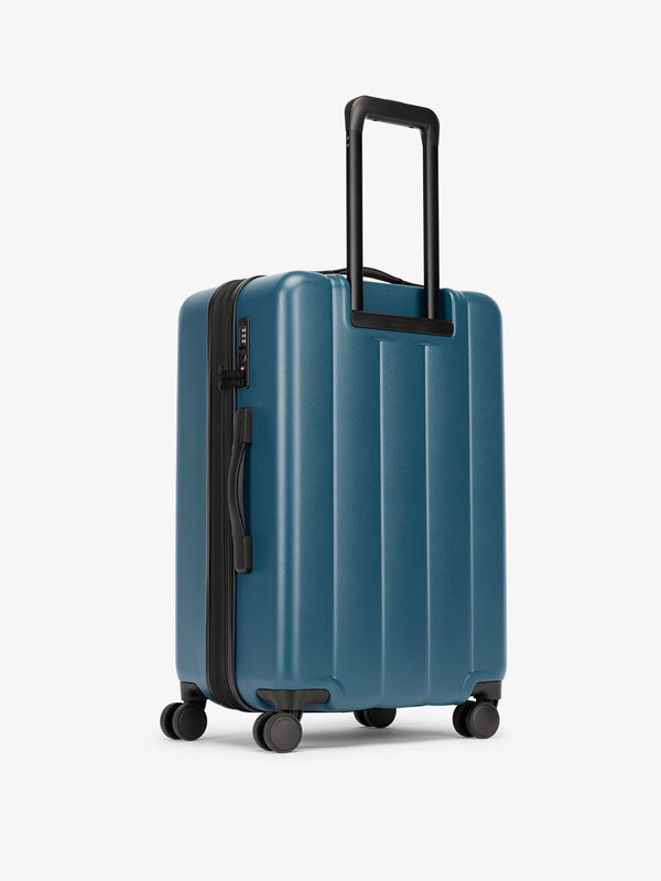 CALPAK medium luggage featuring dual spinner wheels and bottom grab handle in blue
