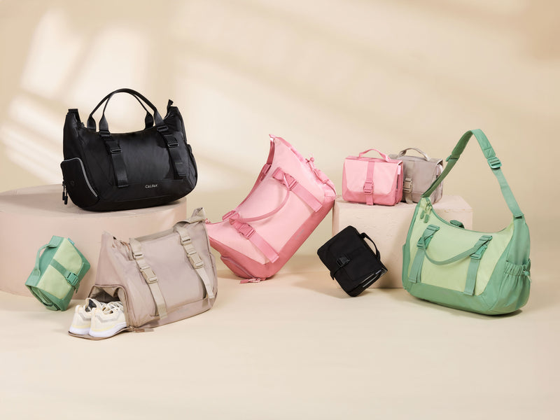 CALPAK Fit Gym Collection products laid out, including black, pink, green, and beige Fit Gym Bags and Toiletry Bags
