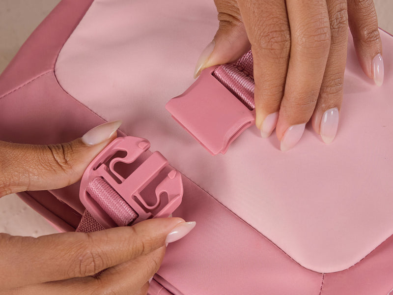 CALPAK Fit Collection Hanging Dopp Kit in pink Tea Rose being clipped by model