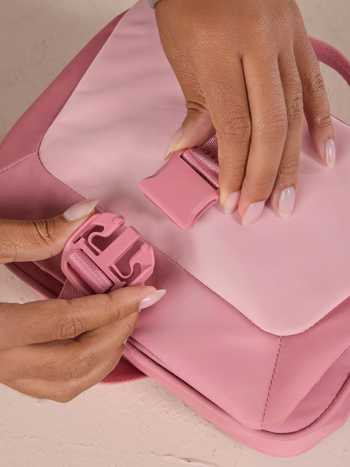 Model buckling front buckle closure of pink CALPAK Fit Hanging Dopp Kit; TFH2401-TEA-ROSE, BTBF2401-TEA-ROSE