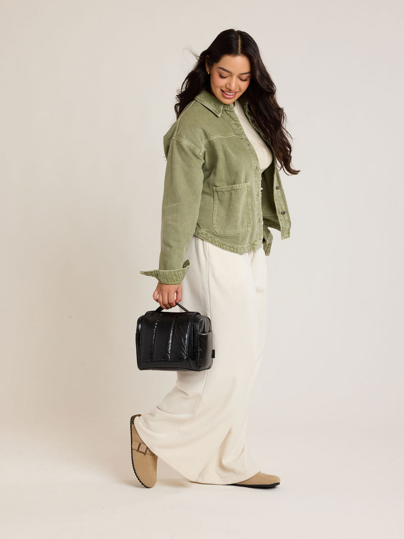 Model carrying CALPAK Luka Hanging Toiletry Bag in Glazed Black