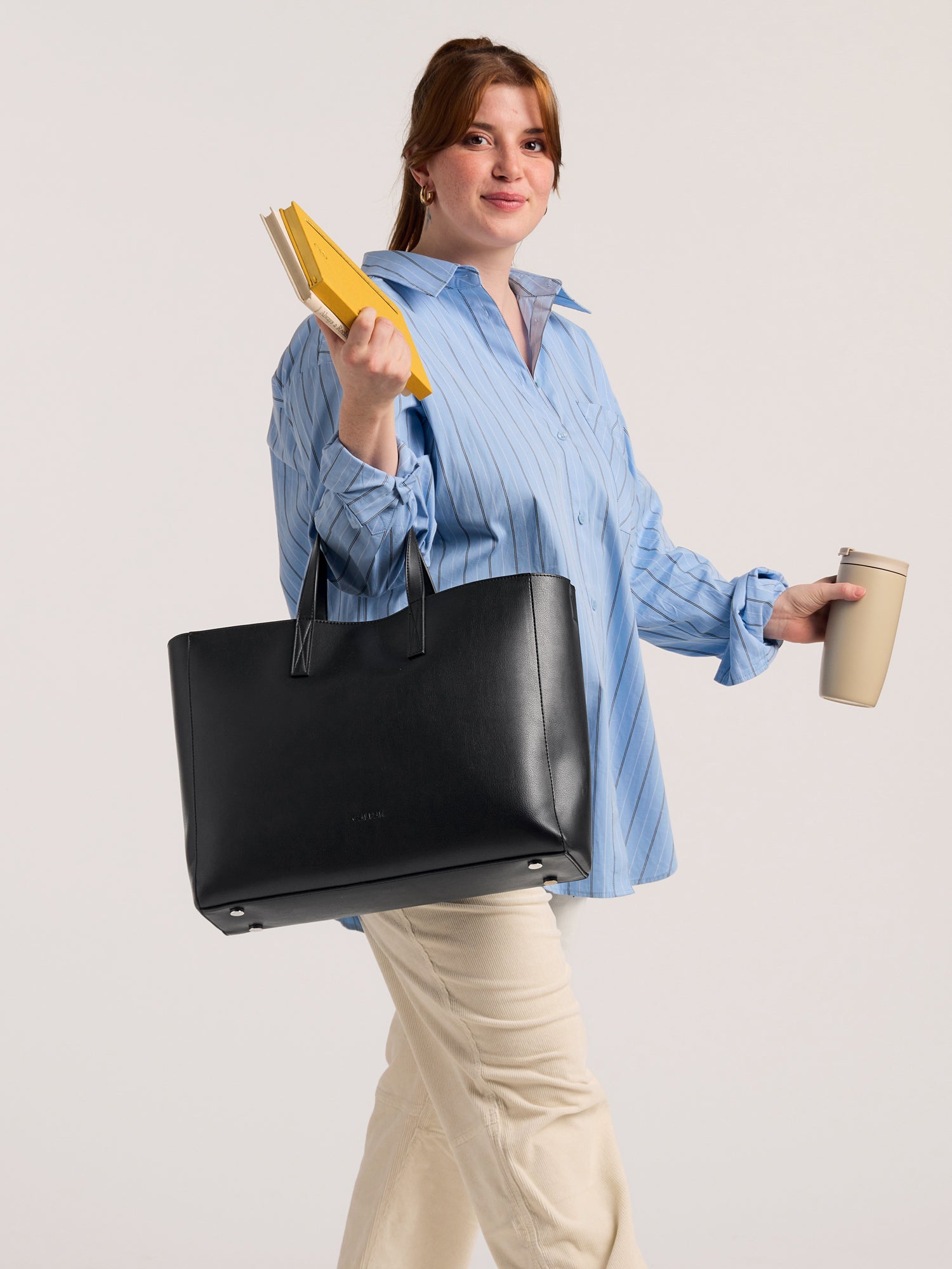 CALPAK Haven Laptop Tote Bag in Black with model carrying it on forearm; ATO2102-BLACK