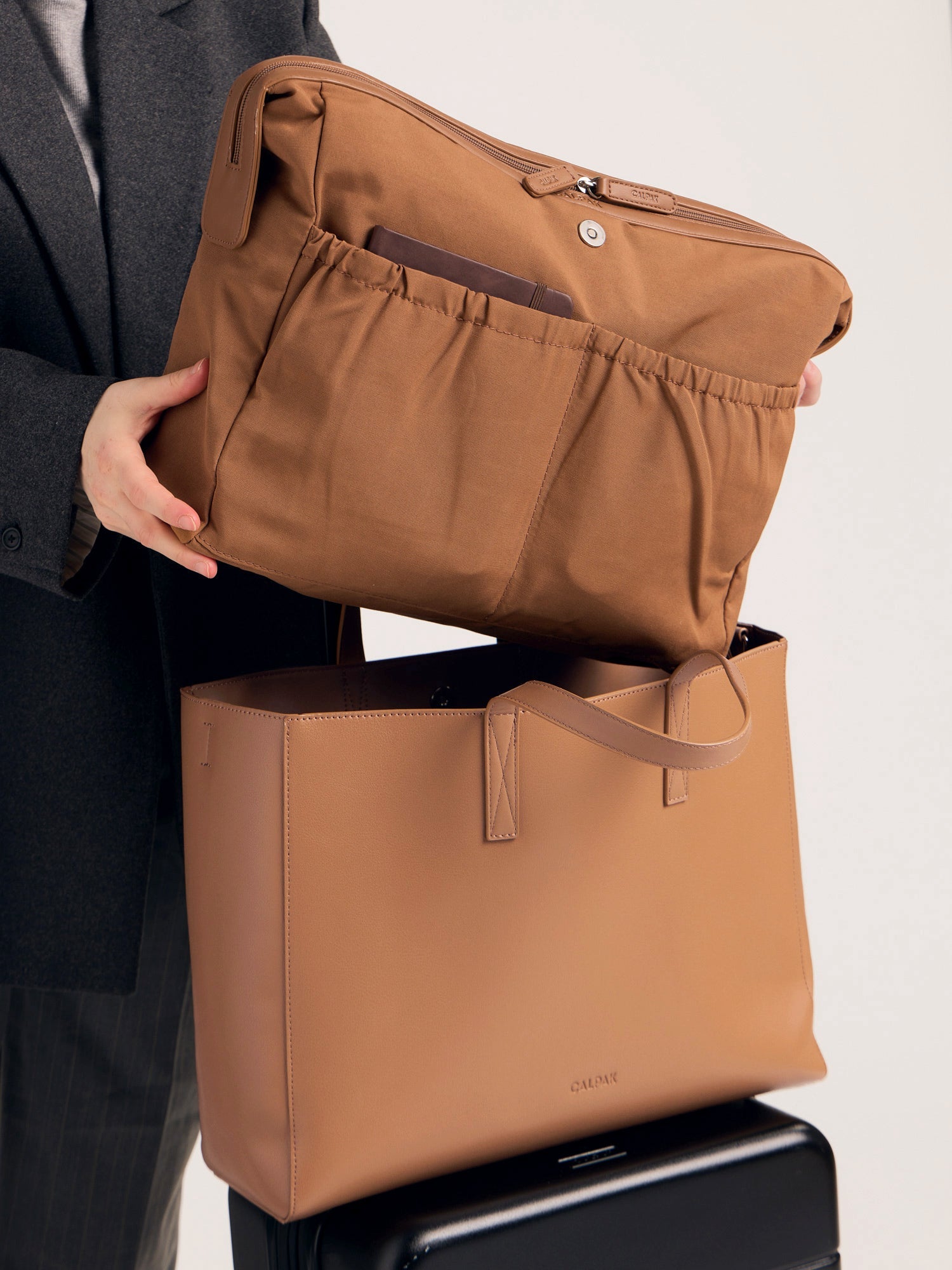 CALPAK Haven Laptop Tote Bag in brown Toffee with model carrying it on shoulder with shoulder strap; ATO2102-TOFFEE