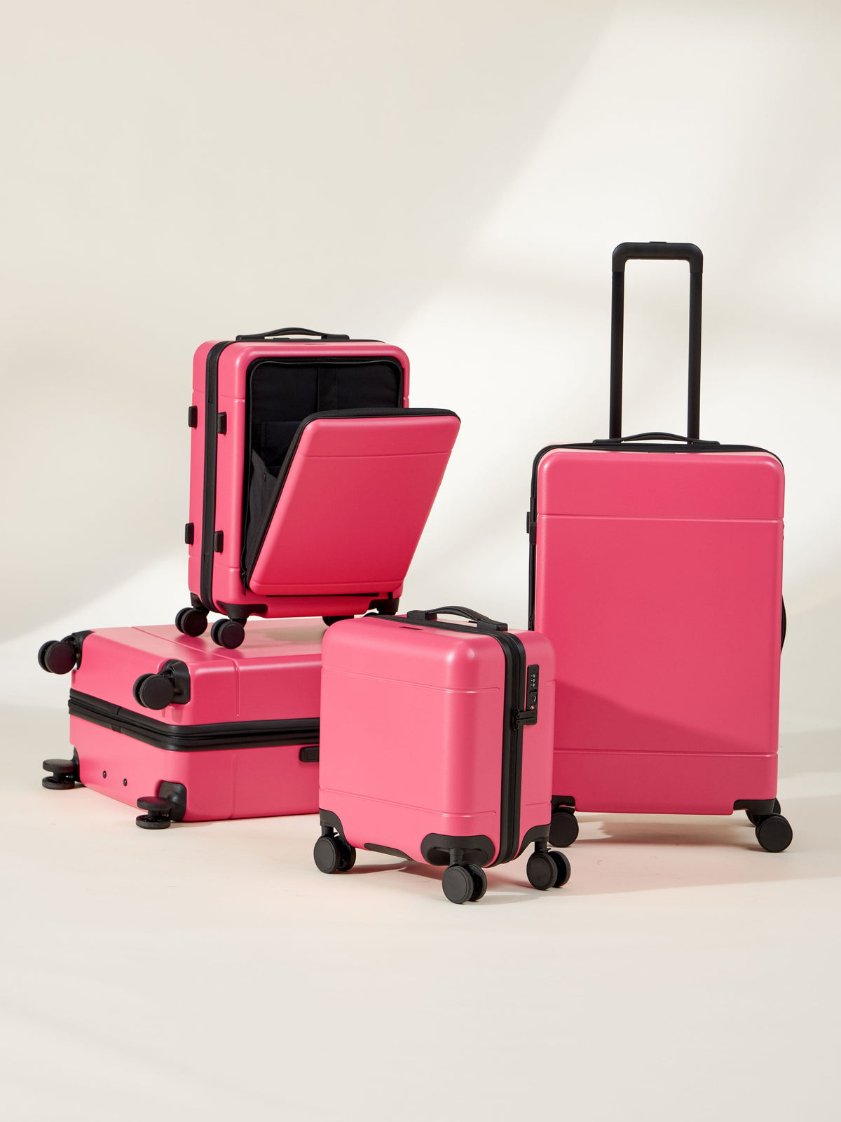 CALPAK Hue Full Luggage Set including Front Pocket Carry On, Mini Carry On, Carry On, and Large Luggage in bright pink dragonfruit; LHU1014-DRAGONFRUIT