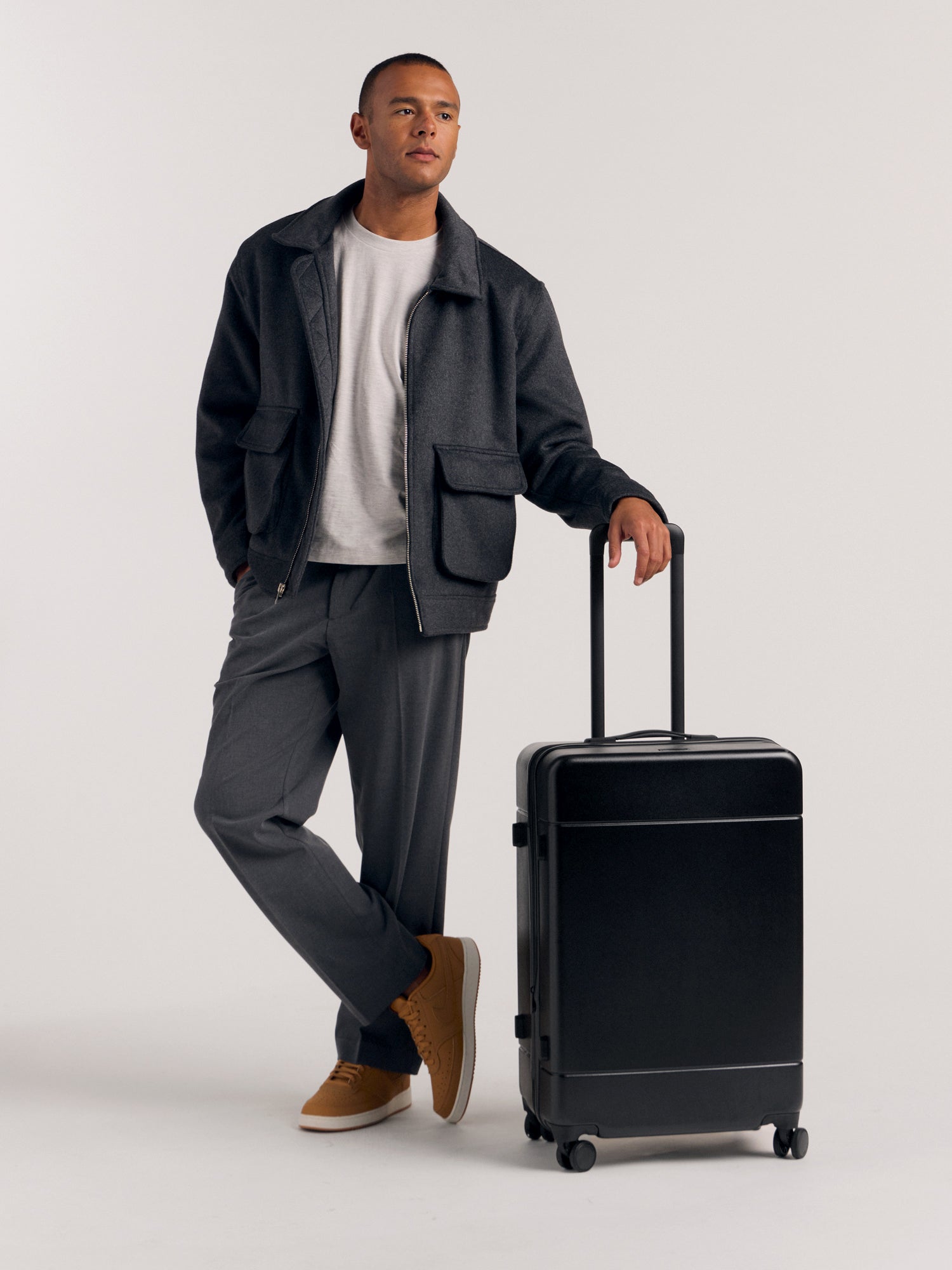 Model with CALPAK Hue Medium Hardside Luggage in black; LHU1024-BLACK