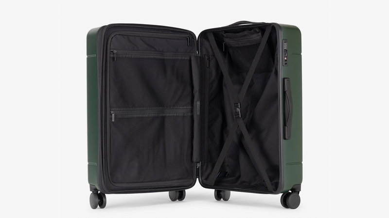 CALPAK Hue Medium Luggage in dark green Emerald that is opened to show capacity of luggage