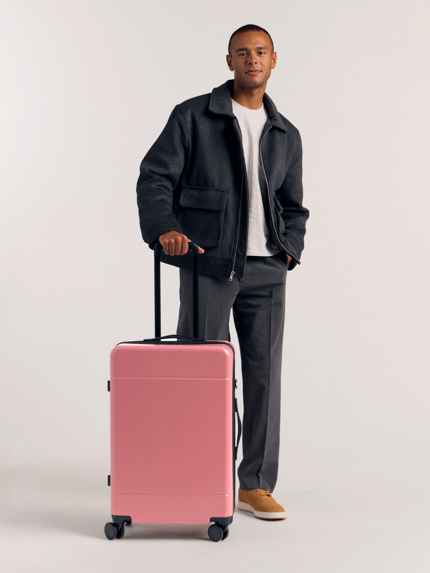 Model with CALPAK Hue Medium 26 inch Hardside Luggage in light pink mauve; LHU1024-MAUVE