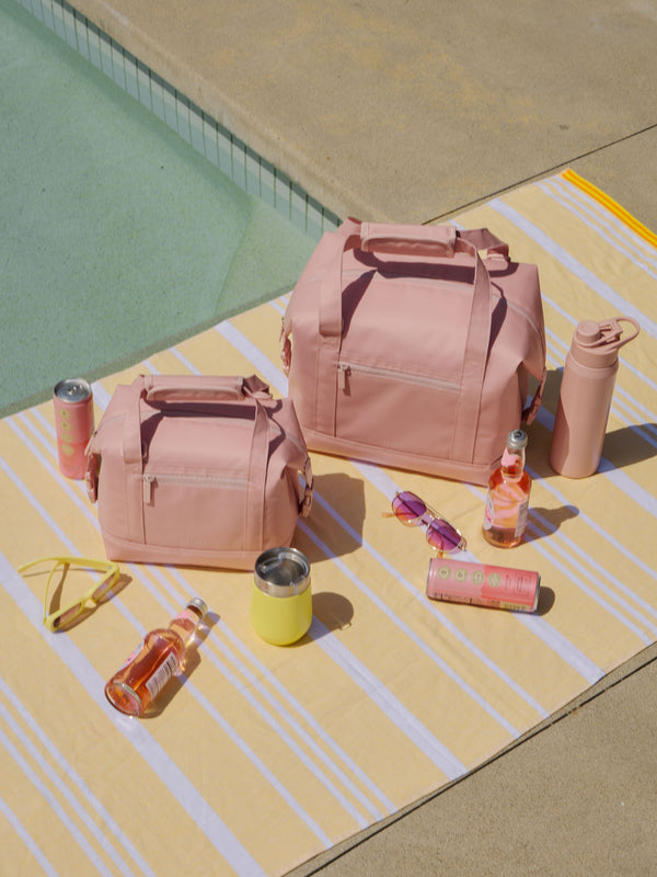 CALPAK Insulated Coolers in 8L and 17L on towel by pool in pink