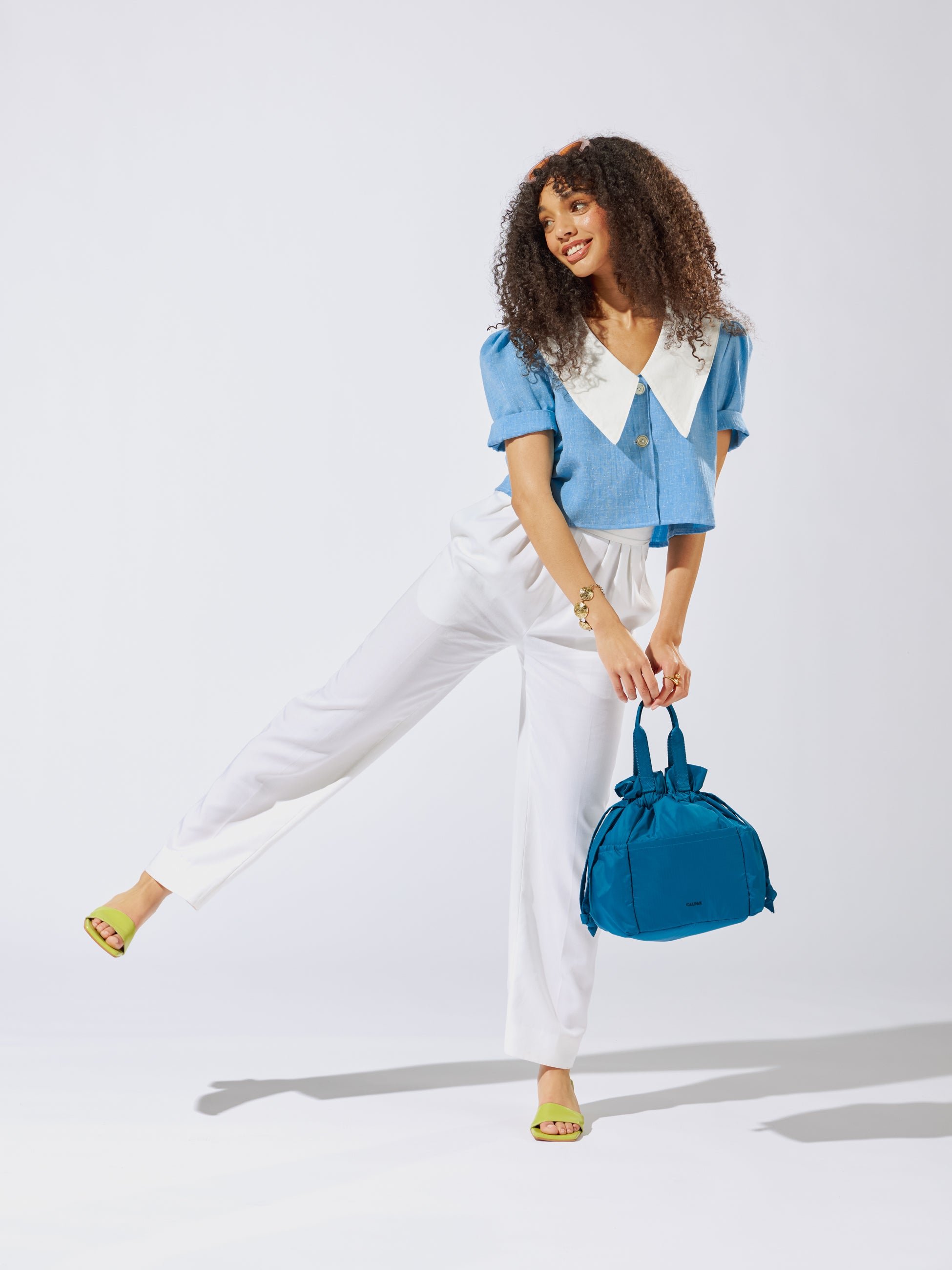 Model holding CALPAK Insulated Lunch Bag for women in lagoon blue
