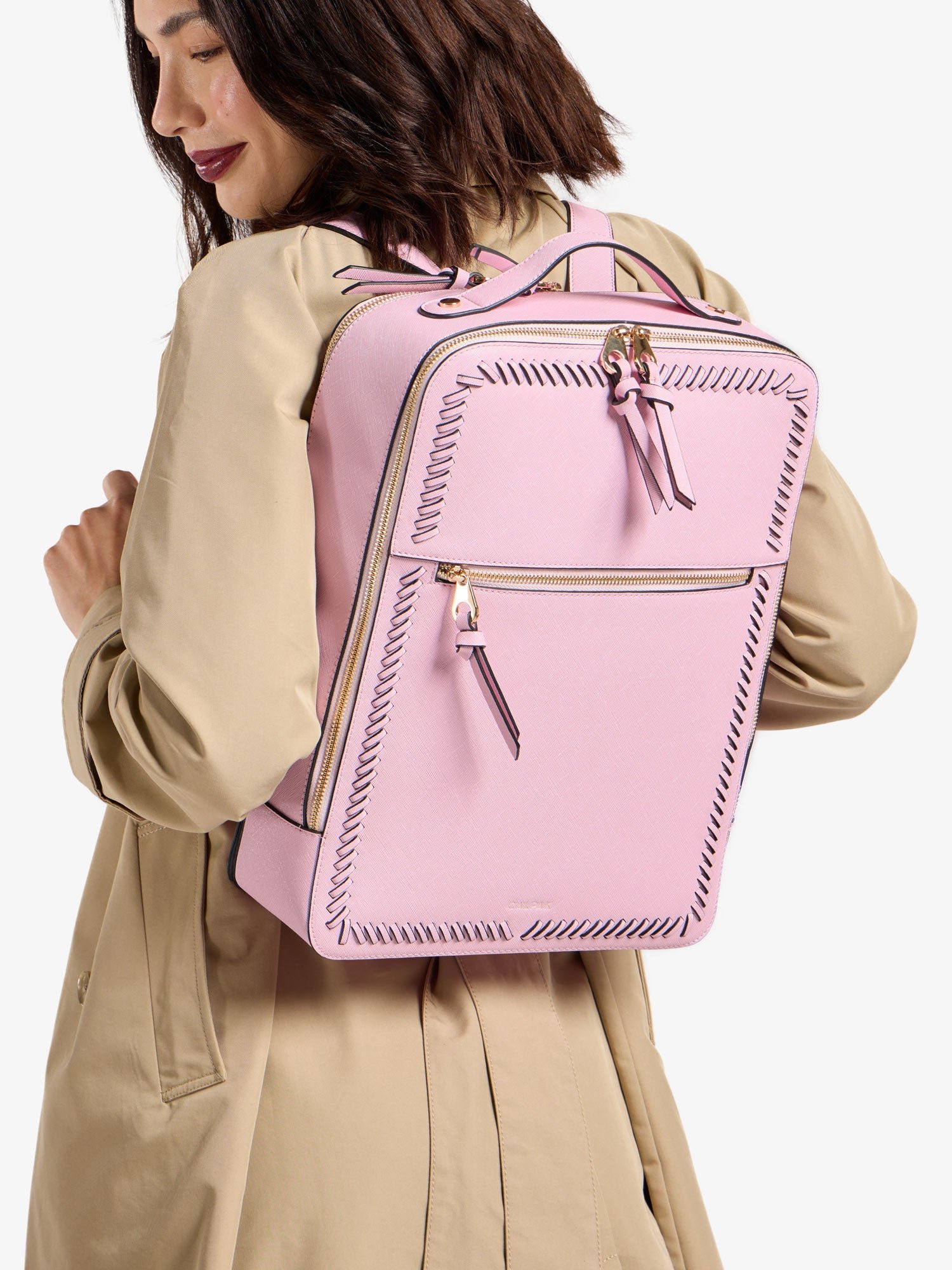 Model wearing faux leather CALPAK 15 inch Laptop Backpack in pink strawberry