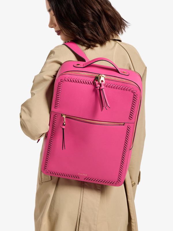 Model wearing CALPAK Kaya 17 inch Laptop Backpack in dragonfruit pink