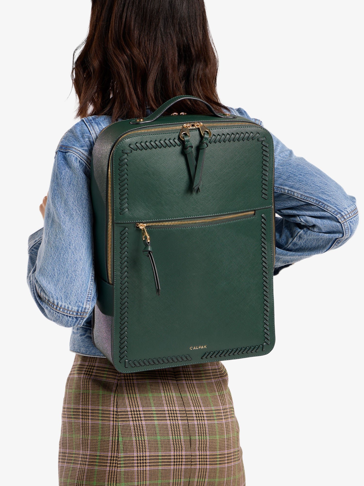 Model wearing dark green CALPAK Kaya 17 inch Laptop Backpack