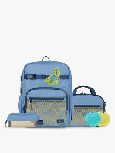 CALPAK Kids Collection Large Kids Backpack Bundle in Blue that includes Kids Lunch Bag, Kids Pencil Case, Rainbow Pluffy Bag Charm, and Set of 2 Ice Packs in a kid's room; BCKL2501-BLUE view 1