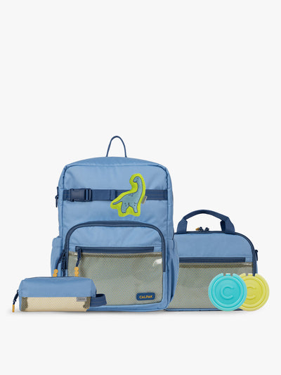 CALPAK Kids Collection Medium Kids Backpack Bundle in Blue that includes Kids Lunch Bag, Kids Pencil Case, blue and green Dinosaur Pluffy Bag Charm, and Set of 2 Ice Packs in a kid's room; BCKM2501-BLUE view 1