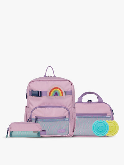 CALPAK Kids Collection Small Kids Backpack Bundle in pink lavender Orchid Pink that includes Kids Lunch Bag, Kids Pencil Case, Rainbow Pluffy Bag Charm, and Set of 2 Ice Packs in a kid's room; BCKS2501-ORCHID-PINK view 1