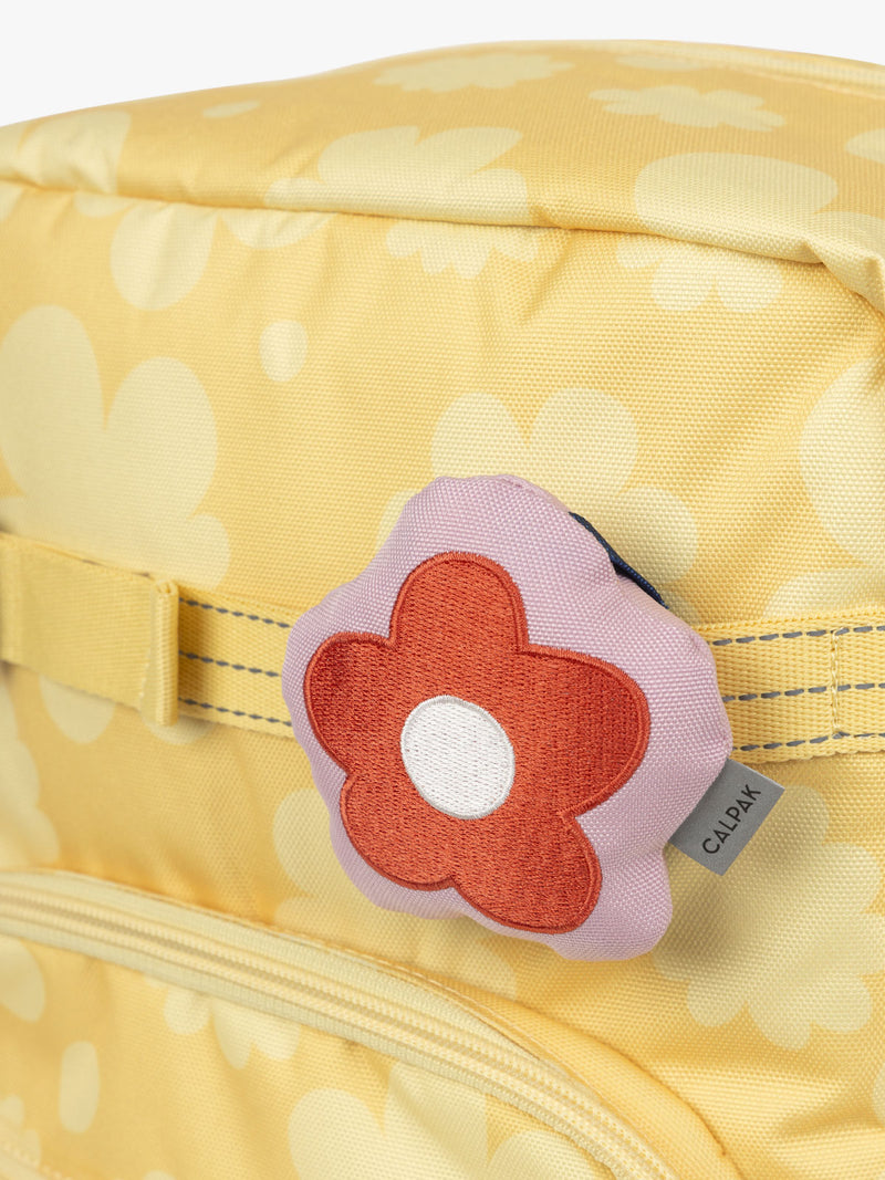 CALPAK Kids Collection red and pink Flower Pluffy Bag Charm attached to Kids Large yellow flower print Yellow Bloom Backpack