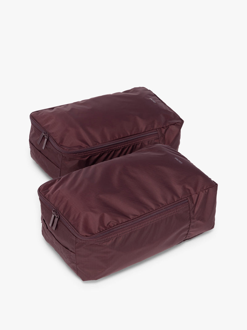 Closed zipper view of the burgundy Dark Cherry rectangular CALPAK shoe cube with zippers and top handle shown on a plain background