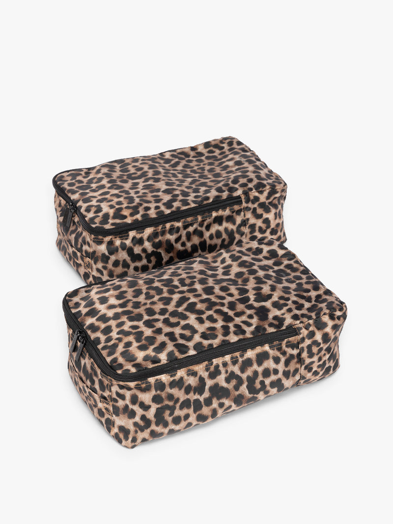 Closed zipper view of the tan and black animal print Leopard rectangular CALPAK shoe cube with zippers and top handle shown on a plain background