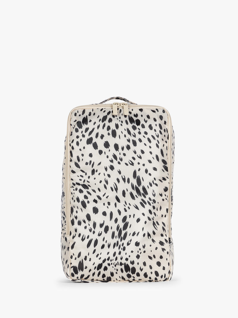 White and black animal print Snow Leopard rectangular CALPAK shoe cube with zippers and top handle shown on a plain background
