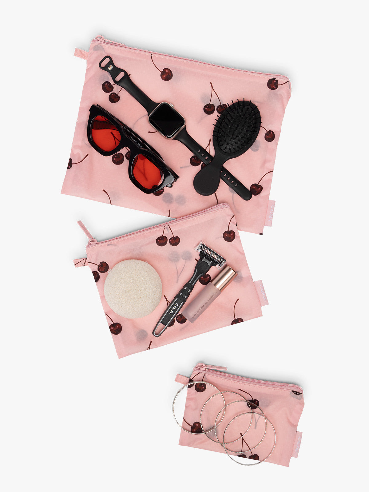 CALPAK  Compakt Zippered Pouch in pink with cherry pattern with items inside; KZB2001-BLOSSOM-CHERRY