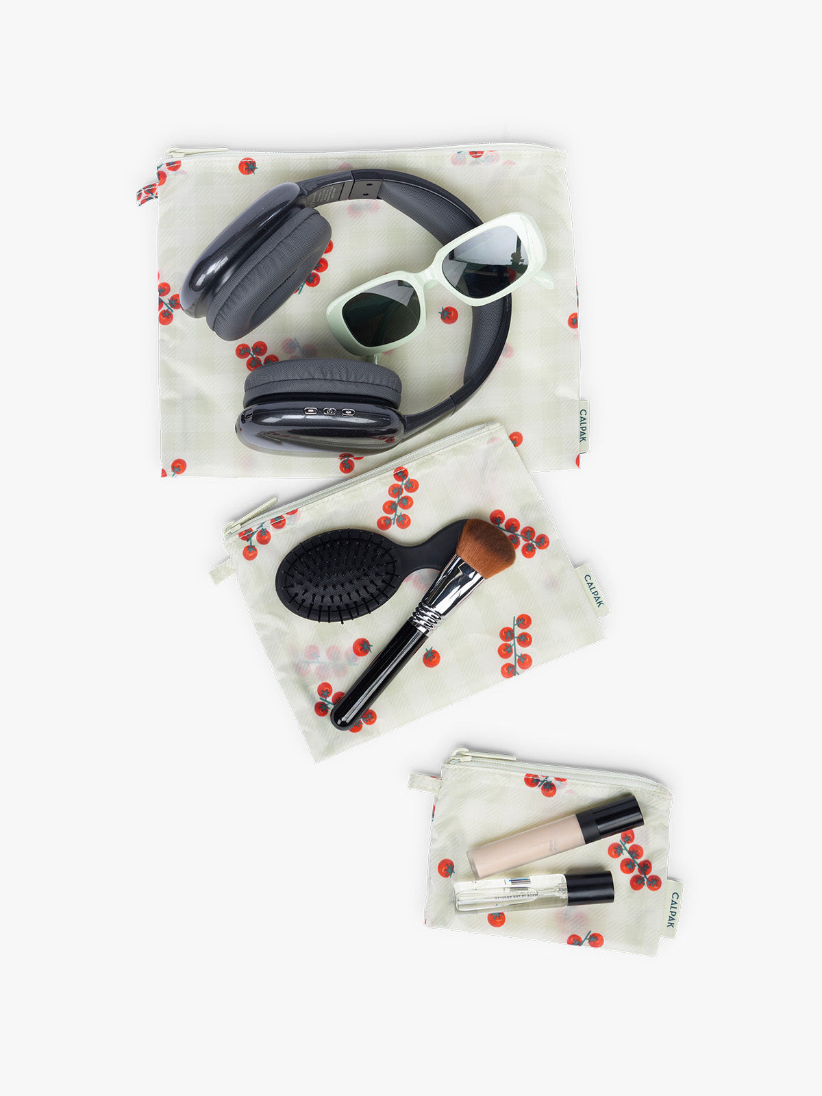Items laid out in what would fit in CALPAK Compakt ZIppered Pouch Set in white and green gingham with tomato print; KZB2001-CELADON-TOMATO-PICNIC