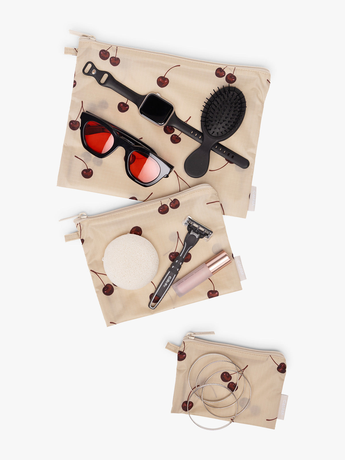 CALPAK  Compakt Zippered Pouch in beige with cherry pattern with items inside; KZB2001-OATMEAL-CHERRY