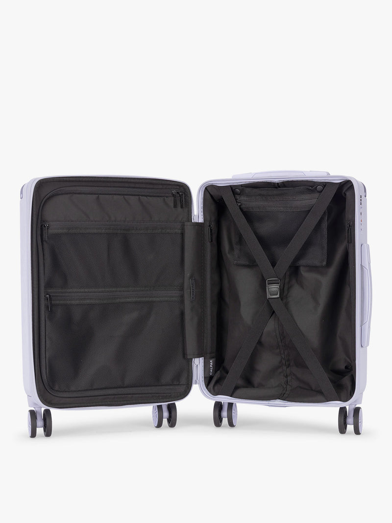 Opened CALPAK Ambeur three piece luggage set in carry on, medium, and large sizes in light purple lavender with handles and spinner wheels on a white background