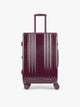 CALPAK Ambeur Medium Luggage in dark burgundy Dark Cherry with vertical ribbed detailing and an extended telescoping handle, shown from the front against a plain white background; LAM1024-DARK-CHERRY