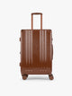 CALPAK Ambeur Medium Luggage in light Honey Brown with vertical ribbed detailing and an extended telescoping handle, shown from the front against a plain white background; LAM1024-HONEY-BROWN