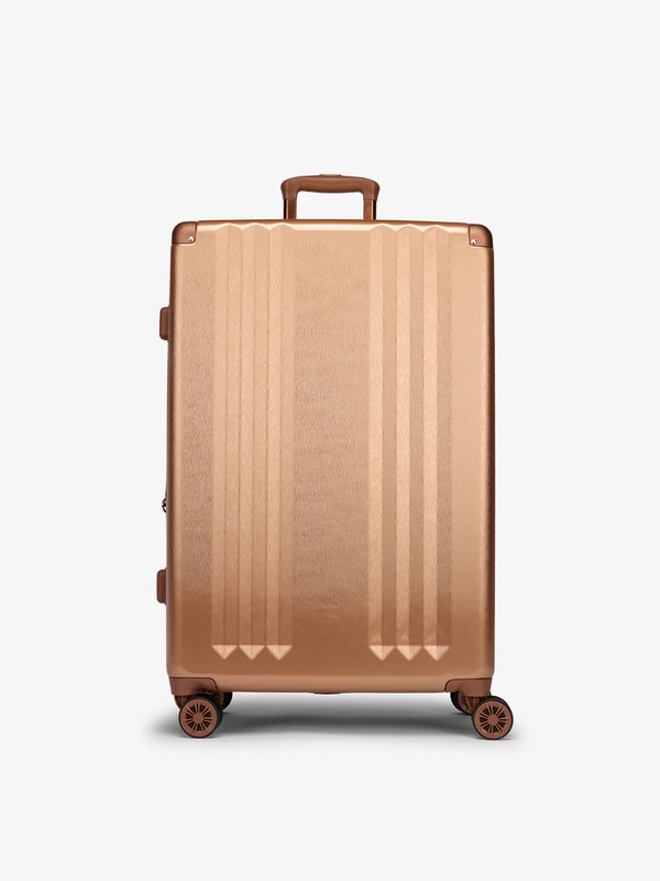 Studio product shot of front-facing CALPAK Ambeur large 30-inch hardshell luggage with 360 spinner wheels in copper