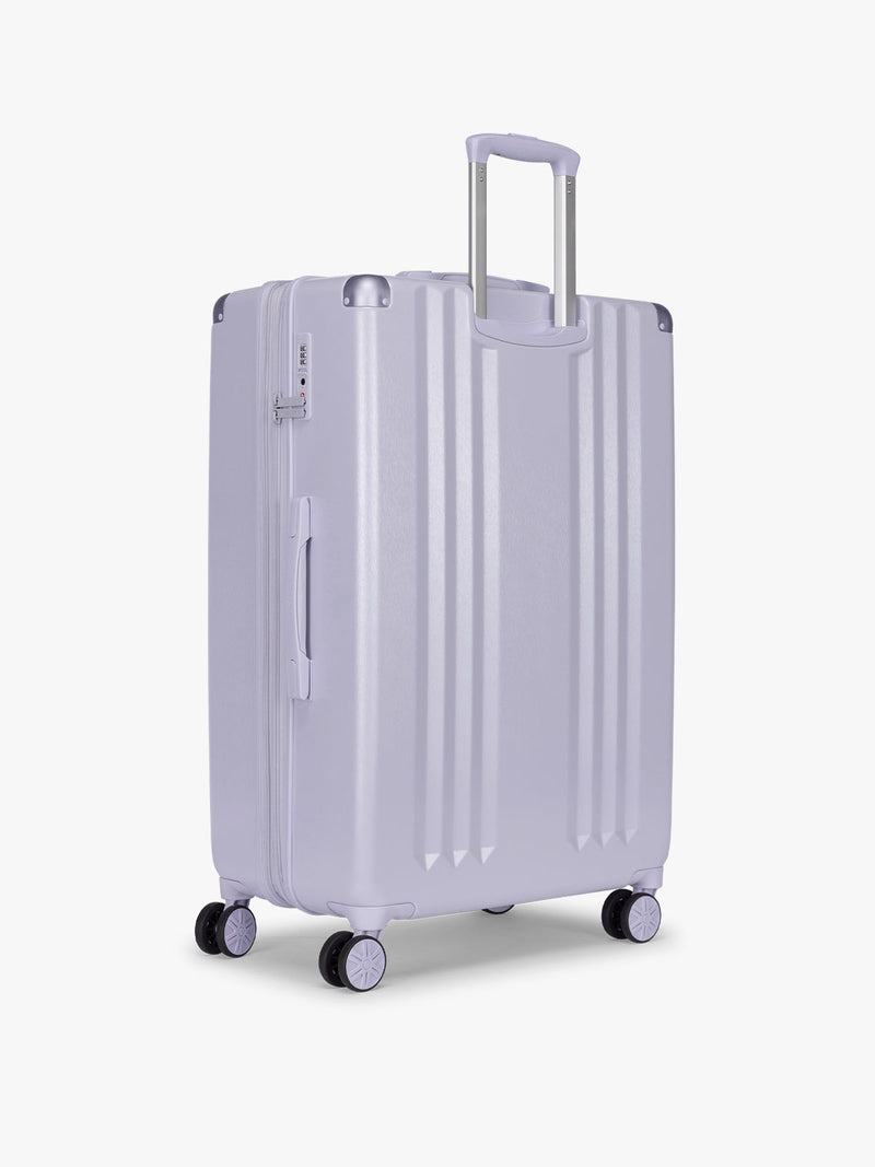 Backside of CALPAK Ambeur Large Luggage in light lavender purple with handles and spinner wheels on a white background