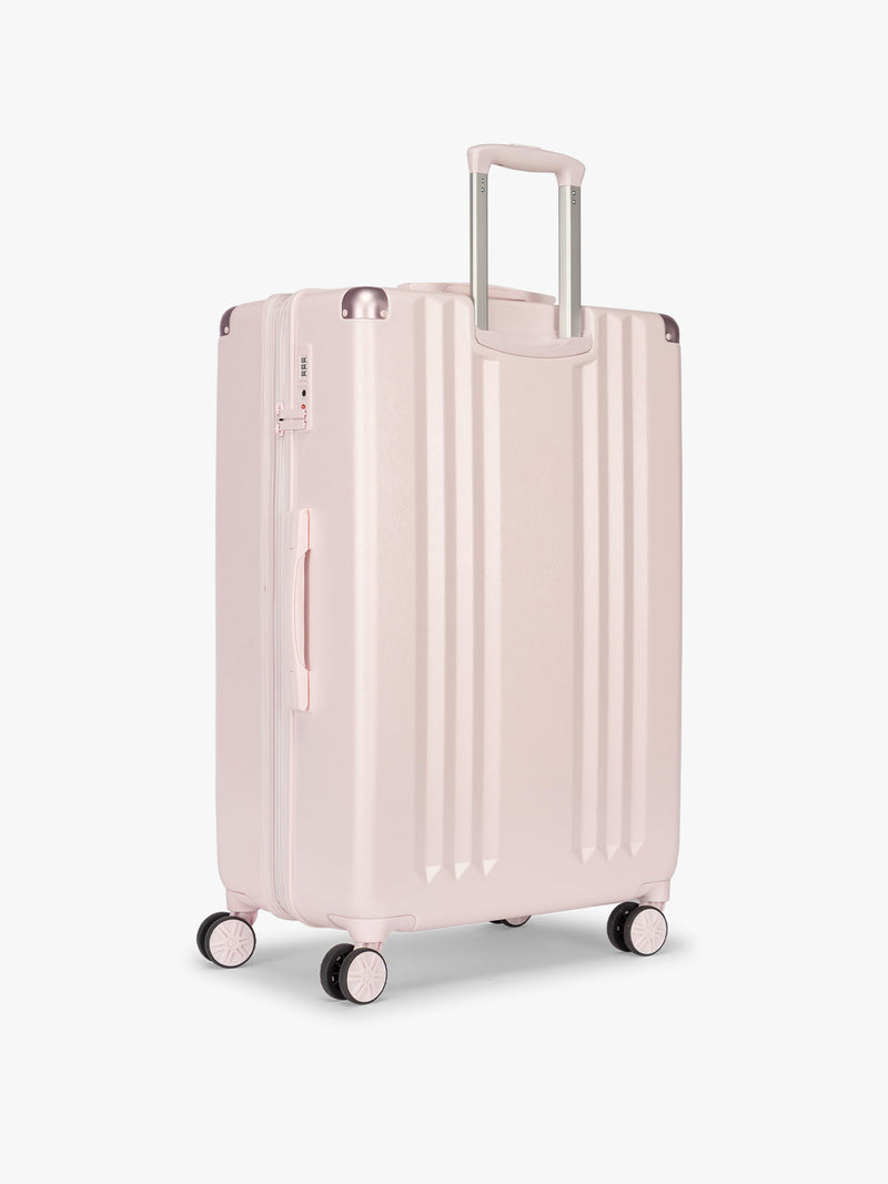 Backside of CALPAK Ambeur Large Luggage in light pink in Shell Pink with handles and spinner wheels