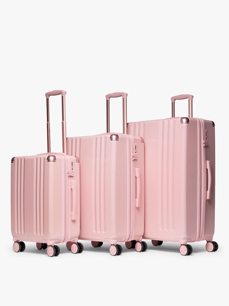CALPAK pc Ambeur Luggage Set featuring the Ambeur Carry-On Luggage, Ambeur Medium Luggage and Ambeur Large Luggage in metallic pink Blossom with pink wheels