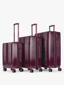 CALPAK Ambeur Three-Piece Set in dark burgundy Dark Cherry, featuring different sizes with telescoping handles extended, set against a plain light gray background; LAM3000-DARK-CHERRY