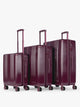 CALPAK Ambeur Three-Piece Set in dark burgundy Dark Cherry, featuring different sizes with telescoping handles extended, set against a plain light gray background; LAM3000-DARK-CHERRY