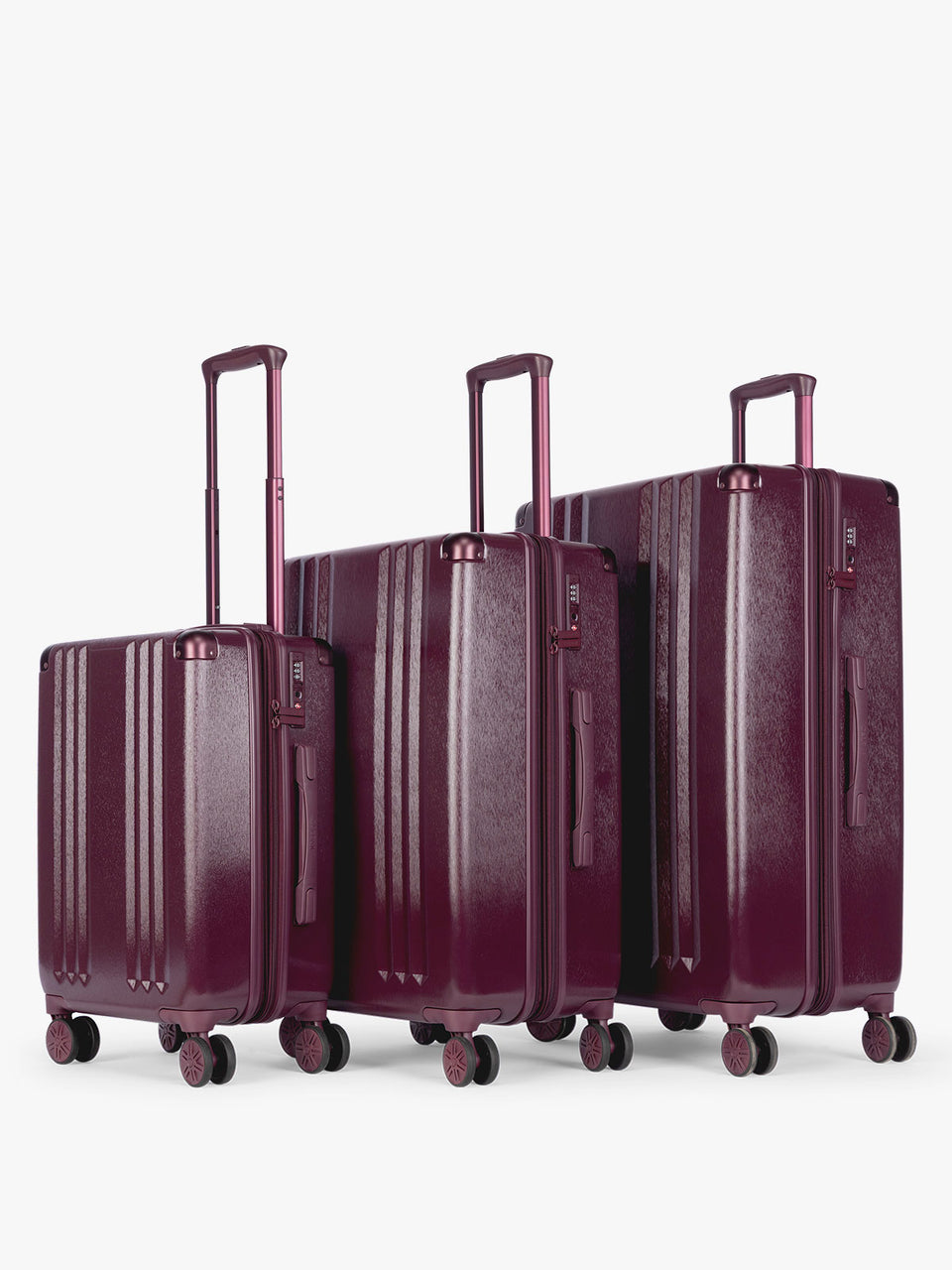 CALPAK Ambeur Three-Piece Set in dark burgundy Dark Cherry, featuring different sizes with telescoping handles extended, set against a plain light gray background; LAM3000-DARK-CHERRY